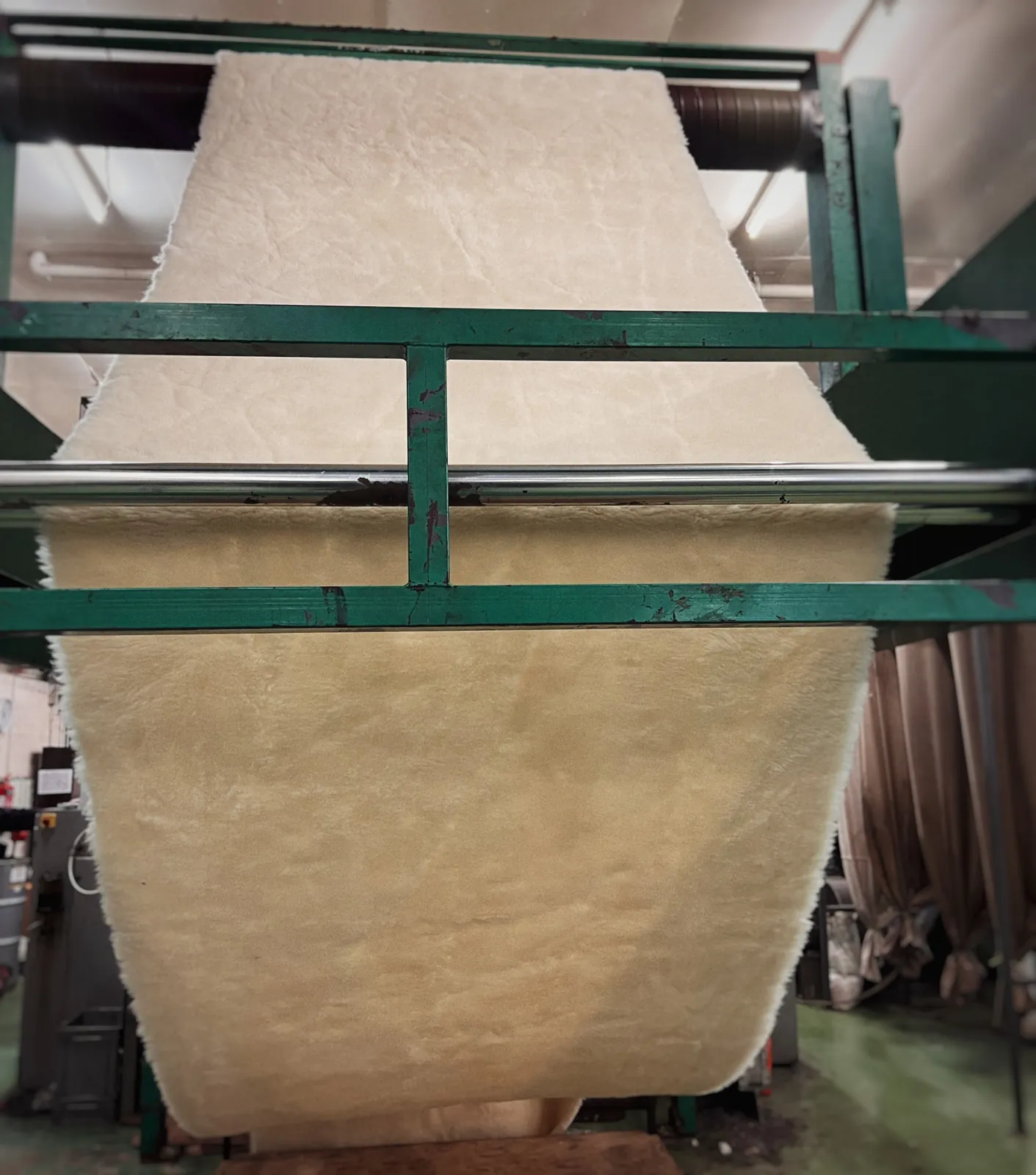 Cream high-pile fabric coming off a sliver-knitting machine at Bowers Mill